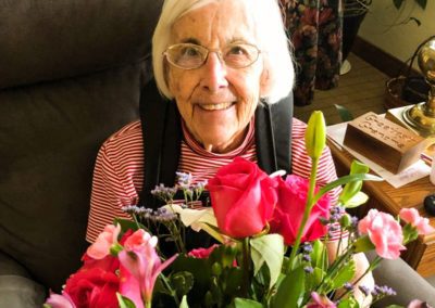 resident smiling holding bouquet of flowers